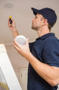 man fixing smoke detector