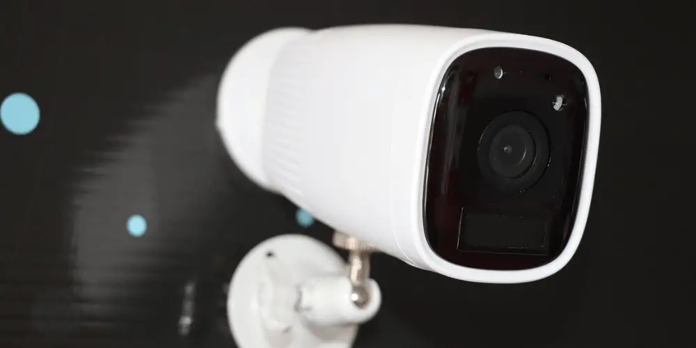 a color white cctv camera mounted on a wall