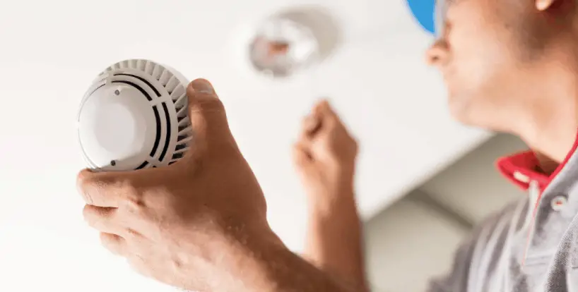 man installing fire alarm