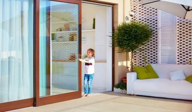 kid opening a sliding door with window film