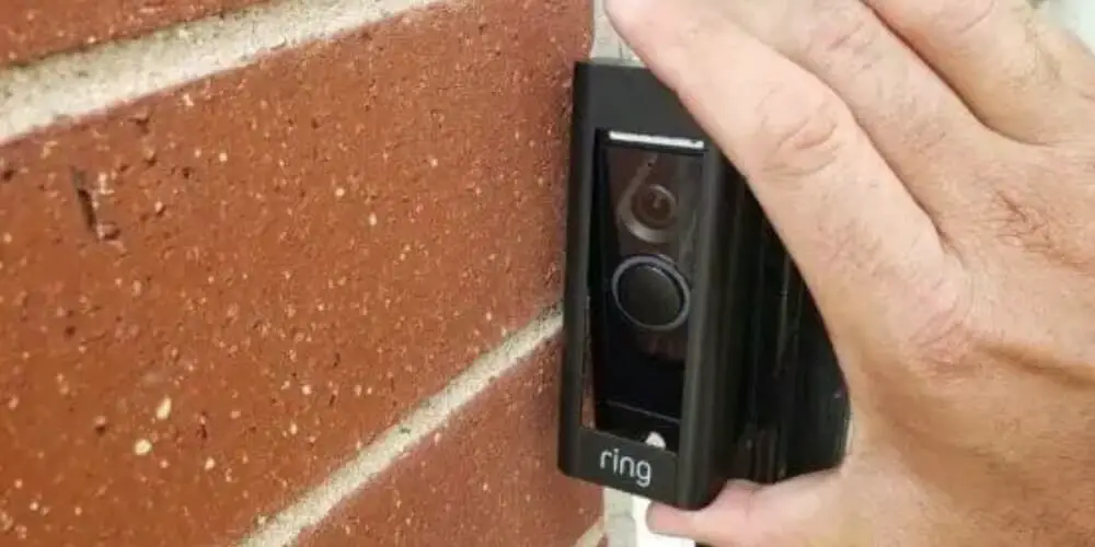 hand holding a Ring doorbell