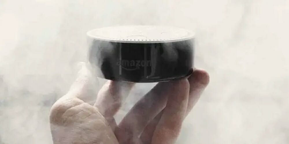 a hand holding an amazon alexa device in a smokey background