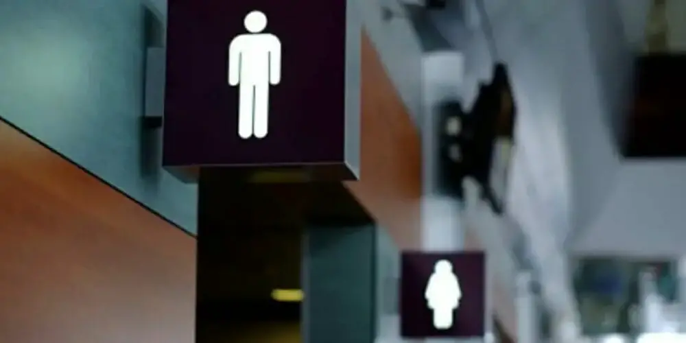 men and women bathroom sign lit