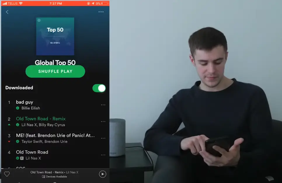 man using his phone connected to alexa and spotify music