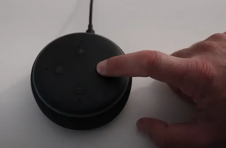 man's pointer finger pressing an alexa button
