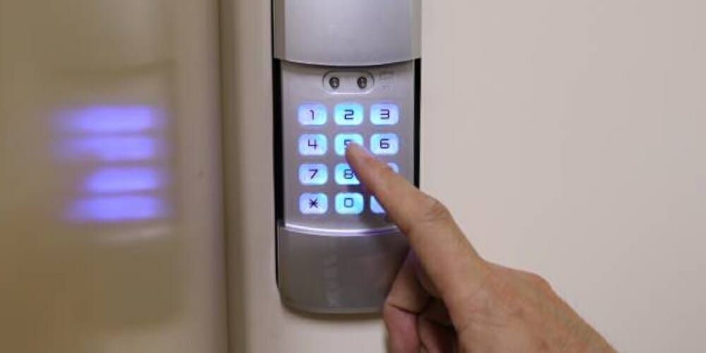 finger pressing number code on keypad door lock