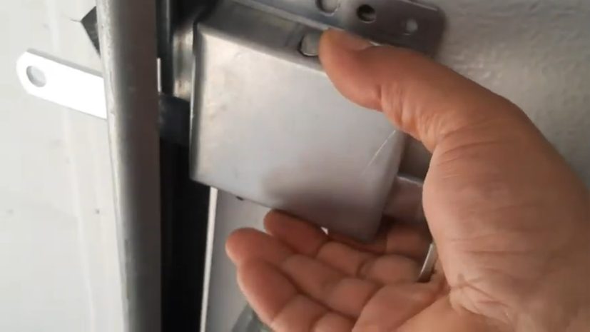 man installing garage door slide lock