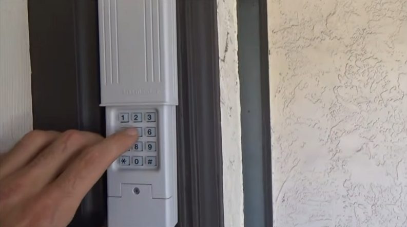 man entering code to a keyless door lock