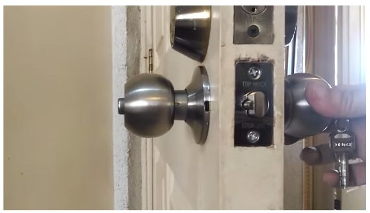 man holding the door lock with attached key