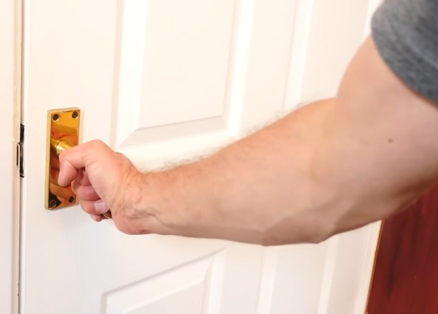 man's hand opening a door