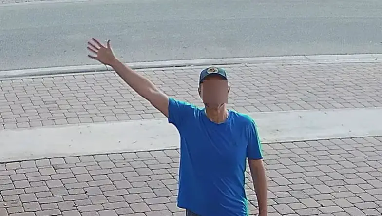 man in blue shirt waving