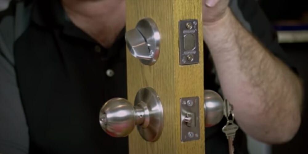 man holding a piece of wood with cylinder lock in zoom
