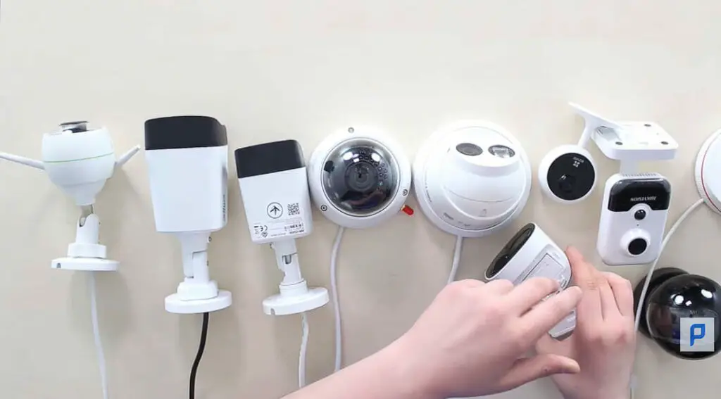 woman's hand placing all types of security cameras