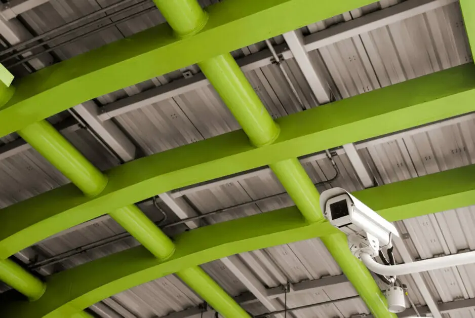 a cctv camera in a roof steel with beams in neon color