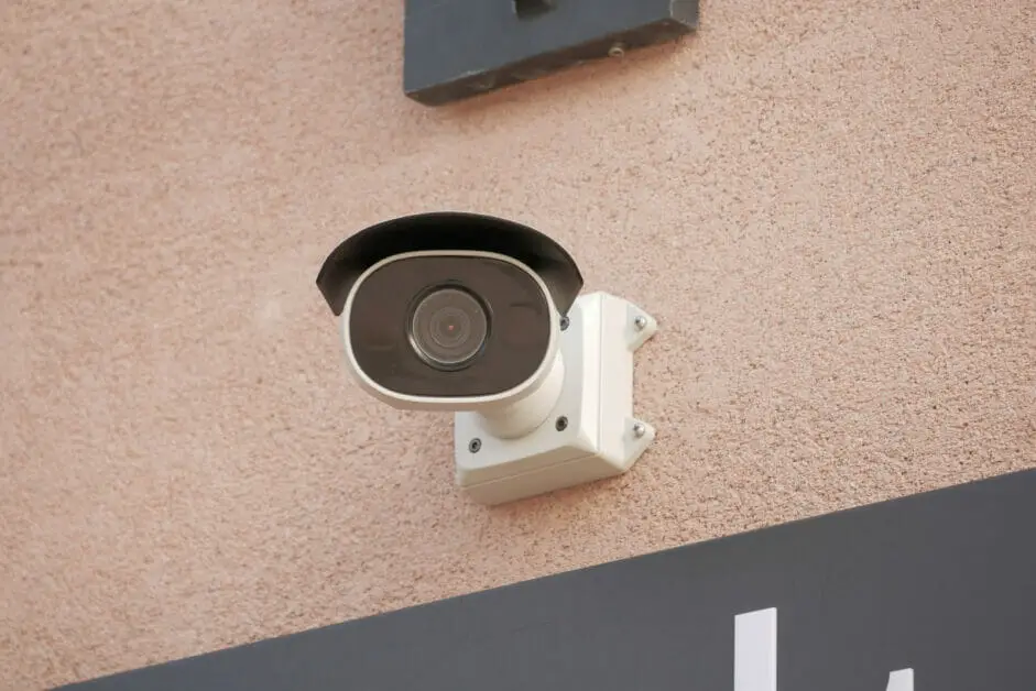 a cctv camera mounted at a stone wall outdoor