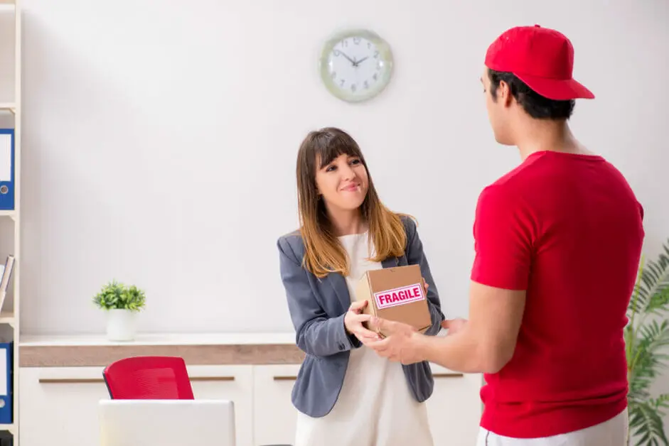 delivery man in red uniform and a woman receiving a package