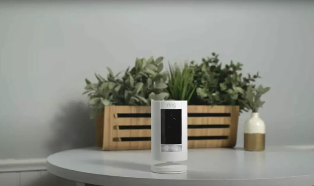 Ring security camera on the table with wood vase for plants on the background