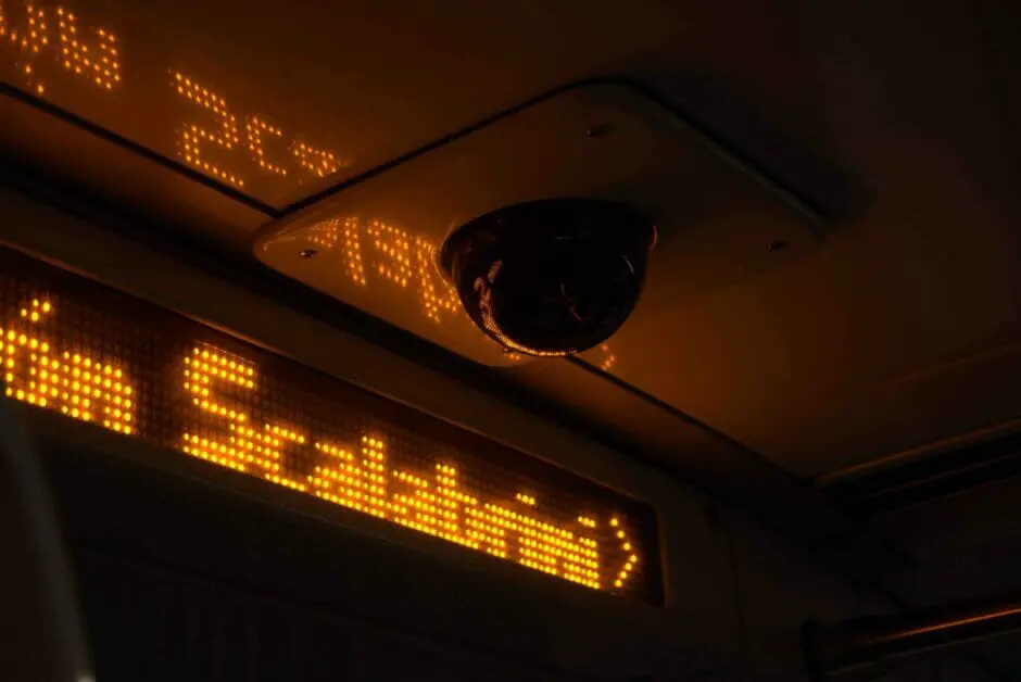 A dim bus with a sign Scalabrini and a security camera